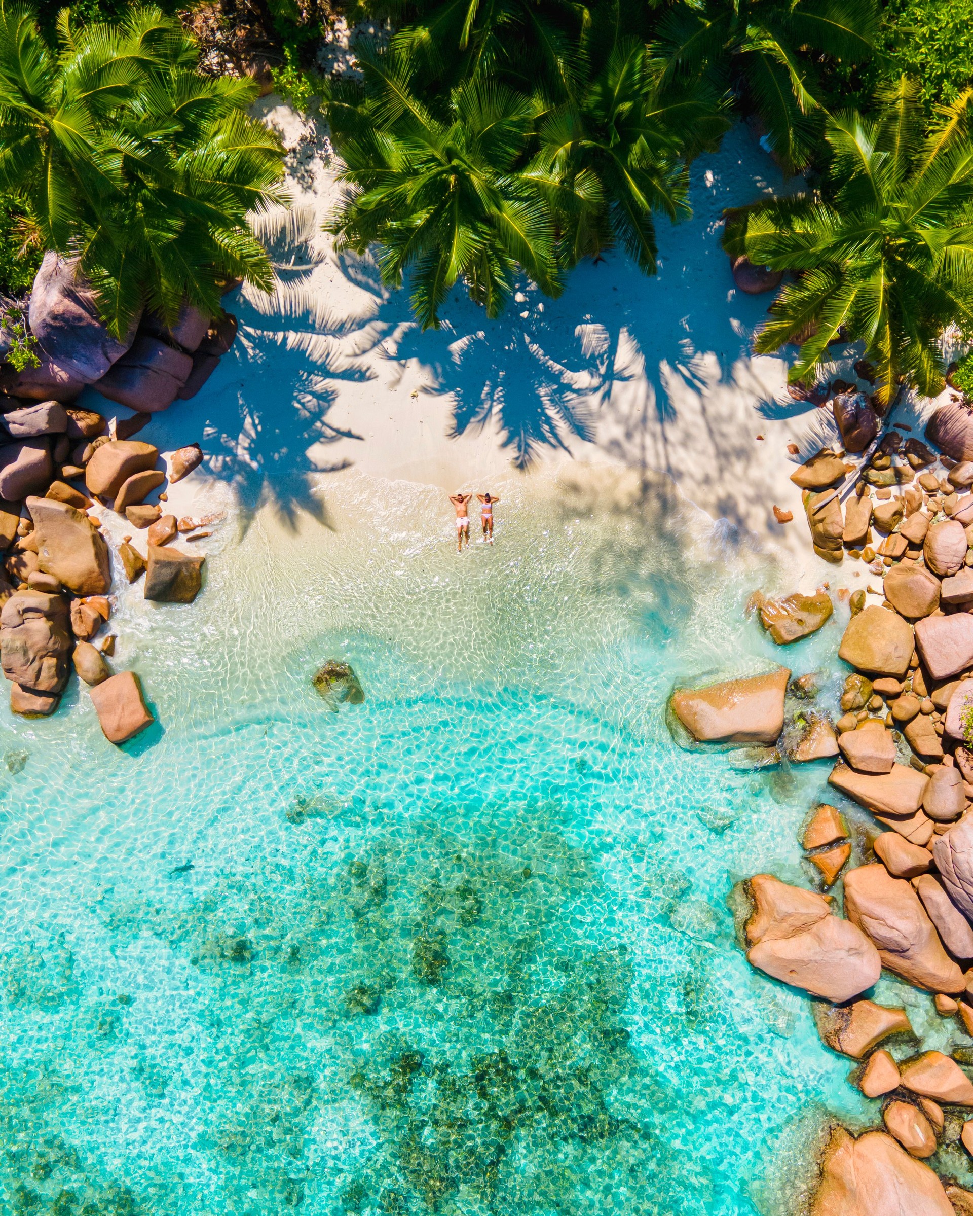 Anse Lazio Praslin Seychelles, young couple men and woman on a tropical beach during a luxury vacation in the Seychelles. Tropical beach Anse Lazio Praslin Seychelles